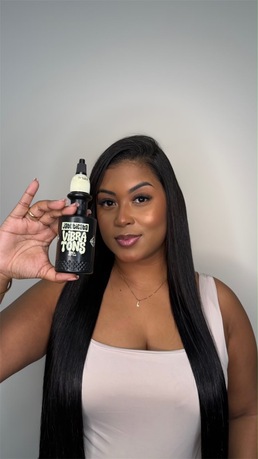 Mulher com cabelo preto longo segurando Vibra Tons